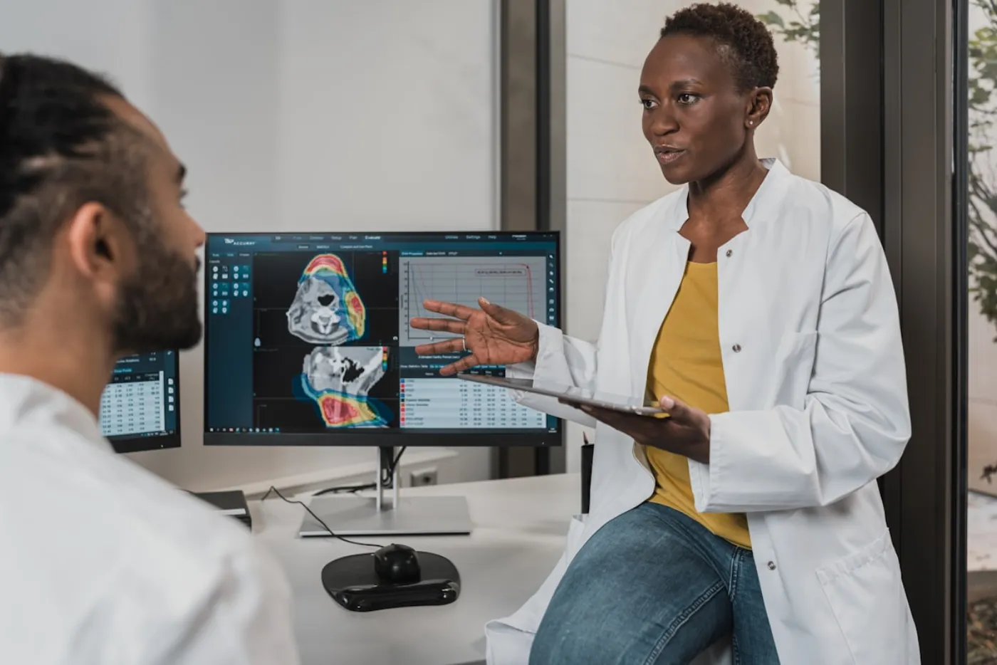 Deux cliniciens analysant une imagerie médicale sur écran